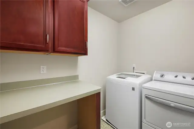 Upstairs Laundry Room with counter and cabinets for storage.