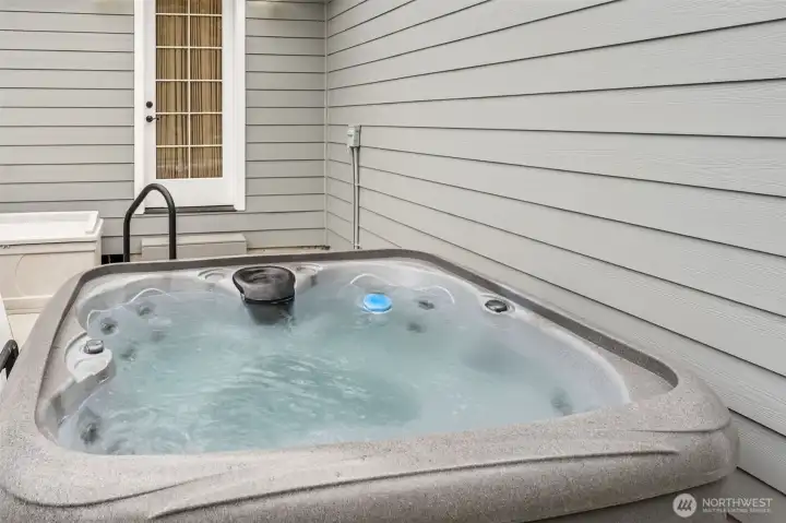 New hot tub off primary suite with new concrete and privacy fencing
