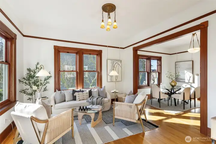 The living room features high ceilings and original millwork.  High-end Anderson windows have been added.