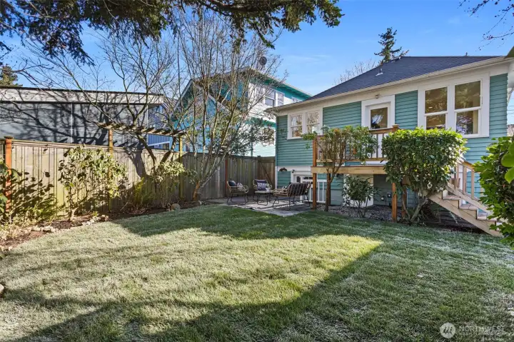 The backyard sanctuary is so private and features a patio and lawn surrounded by mature plantings.