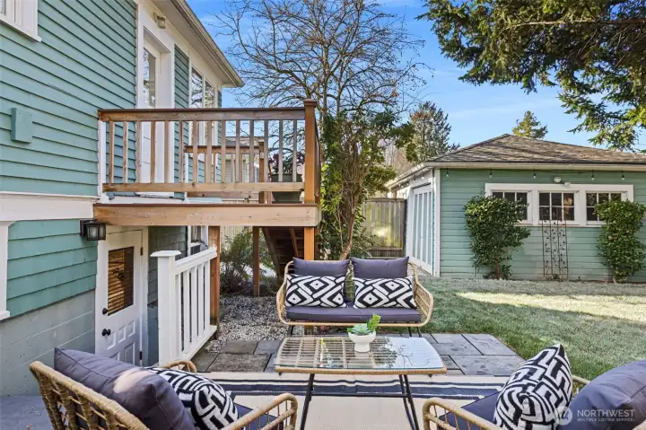 Patio looking toward the 1 car detached garage.  Here you may also see the separate entry into the lower level of the home.