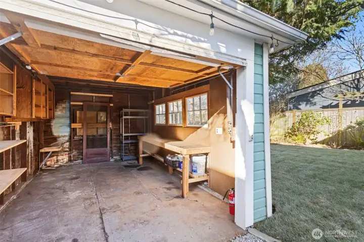 1 car detached garage with work bench and storage shelves.