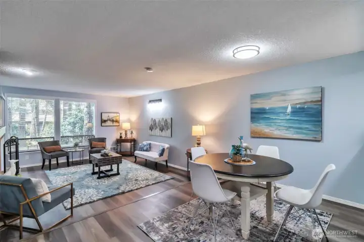 View of living room and dining room.  Updated vinyl flooring.  View of landscaping from kitchen,dining room and living room.