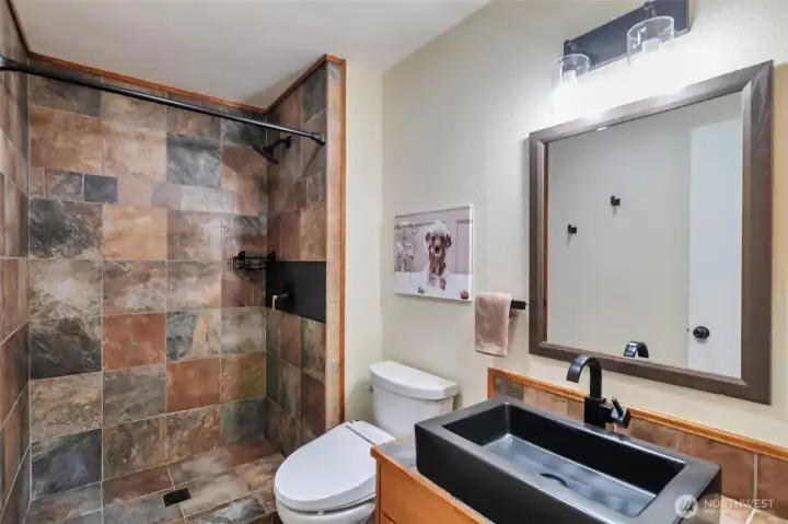 Master bathroom has slate shower, heated toilet seat and modern updated sink.