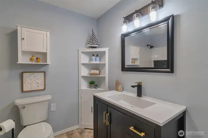 Guest bathroom updated with fresh paint, new flooring,shower/tub area and updated cabinetry.