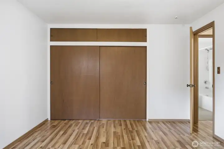 There is a closet in the second bedroom with storage cabinets above.