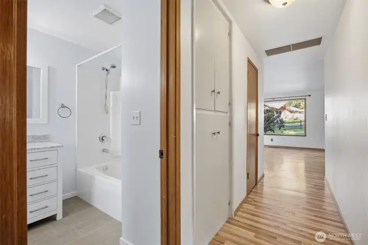 Looking down the hallway with the built-ins and coat closet adjacent to the updated bathroom.