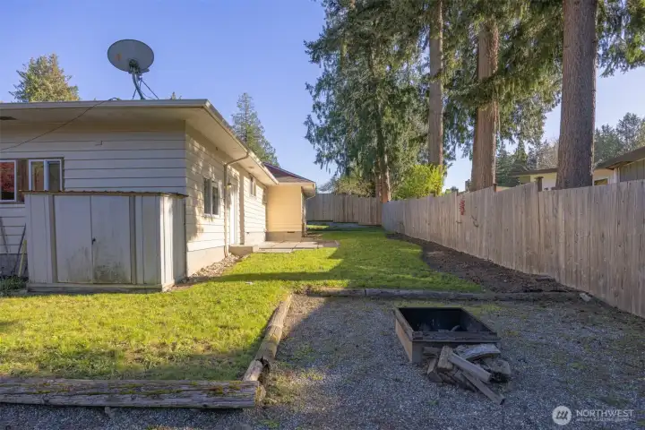 The lower portion of the rear yard has a little fire pit area and there is also a small garden storage shed.