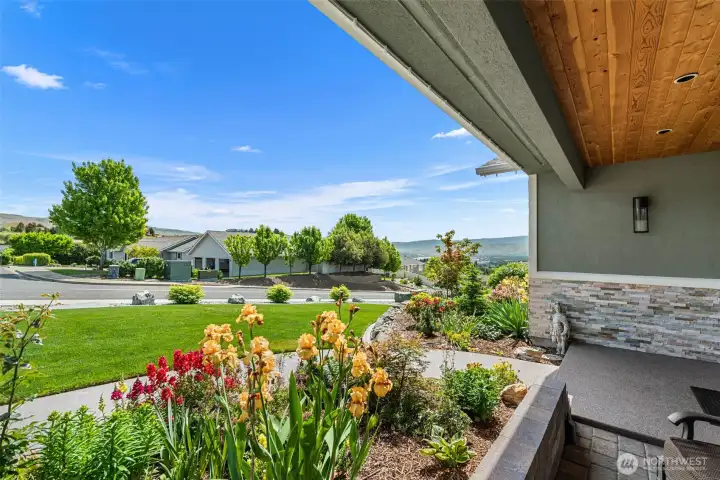 Thoughtfully designed landscaping with tiered rockery, manicured lawn, and colorful plantings enhances the home’s polished aesthetic look.