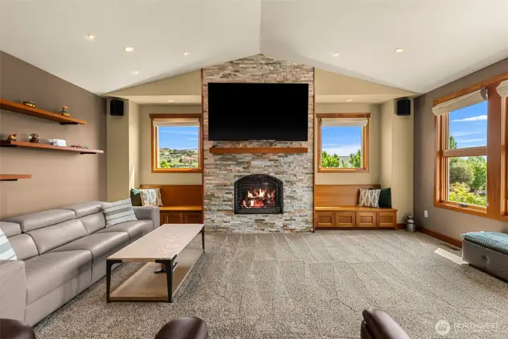while rich wood trim and a floor-to-ceiling stacked stone fireplace create a warm Northwest ambiance.