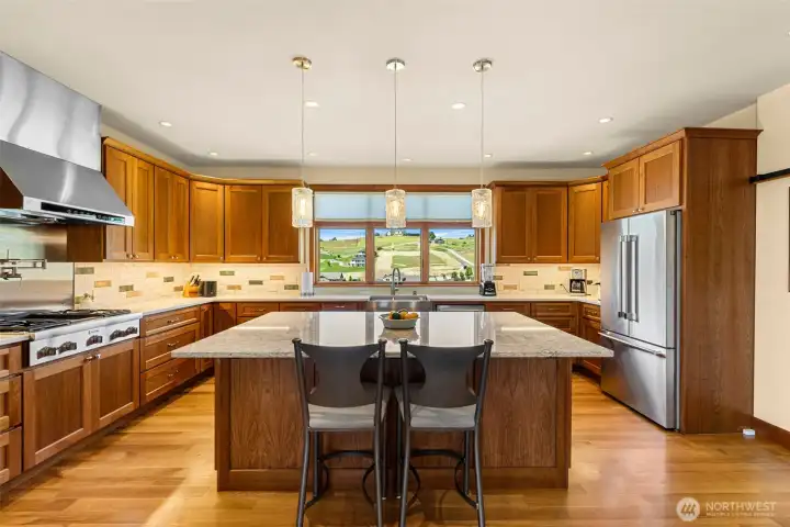 Premium Thermador appliances, including double wall ovens and a professional-grade gas range with pot filler, elevate the space for both everyday living and entertaining.