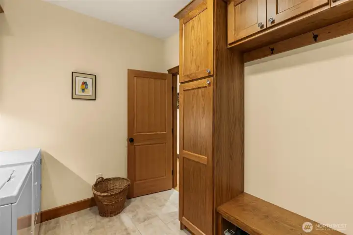 featuring custom built-in cabinetry, bench seating, and durable finishes ideal for everyday organization. Rich wood craftsmanship continues throughout, creating a cohesive aesthetic while offering practical storage for coats, shoes, and household essentials. Conveniently positioned to support effortless day-to-day living.