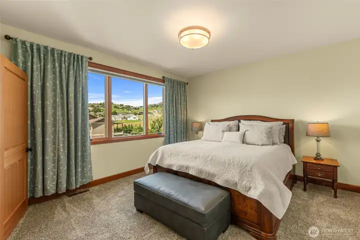 featuring large picture windows that frame peaceful mountain and territorial views while filling the room with natural light. Warm wood trim and plush carpeting.