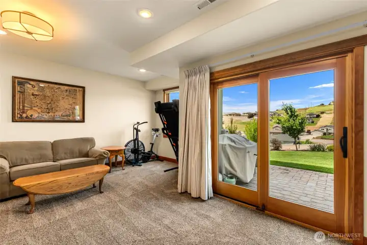 Large glass doors provide abundant natural light and seamless access to the patio and landscaped grounds, creating an inviting indoor-outdoor connection.