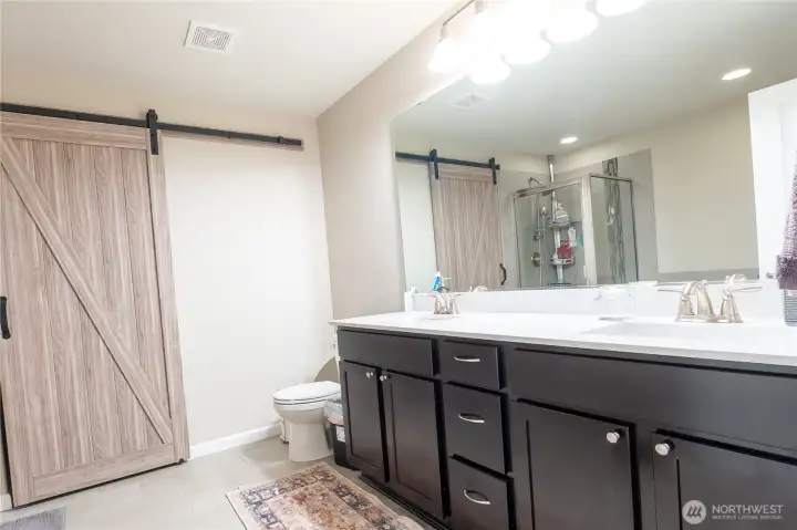 Master bathroom with barn door leading to master closet