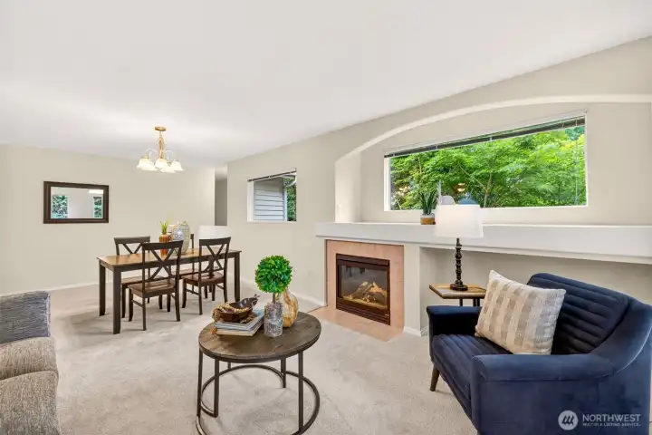 The spacious living and dining great room centers on the fireplace and a wide picture window that floods the space with greenery and light. It's an inviting, flexible heart of the home built for both everyday living and hosting.