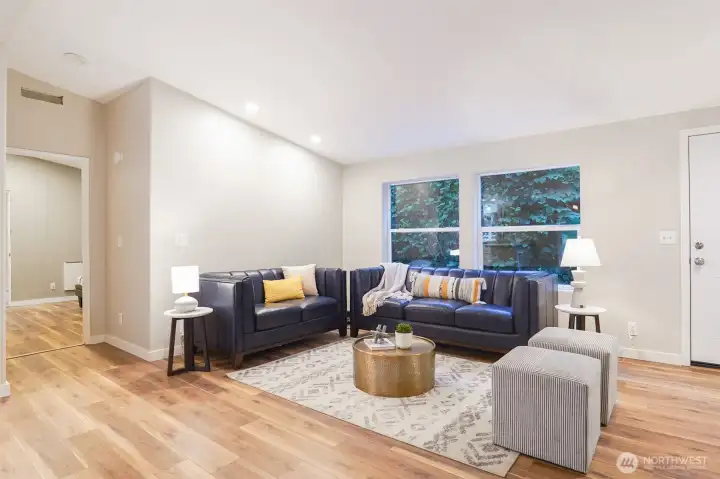 The open-concept living room provides a warm and inviting gathering space with updated flooring and abundant natural light. The open-concept living room provides a warm and inviting gathering space with updated flooring and abundant natural light.