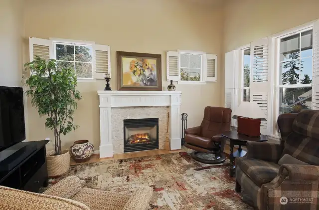 Main level living room with propane fireplace creating warmth and a cozy ambiance on chilly Northwestern evenings. Louvered shutters throughout.