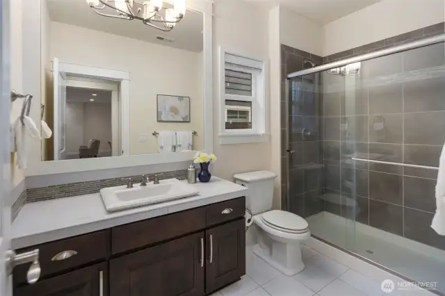 Main level three-quarter bath, tile floor and tile shower surround.