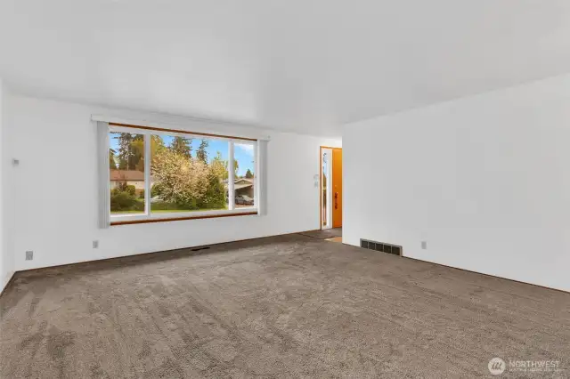 Light & bright living room.  Hardwood floors under carpet in Living room and bedrooms.