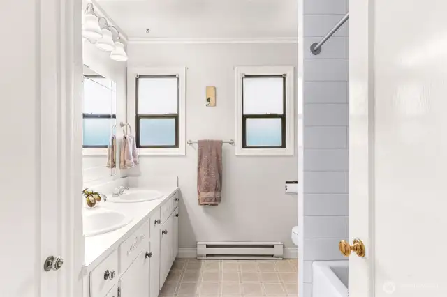 Bright and sunny main bathroom with tub and shower.