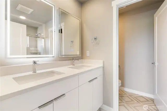 Primary ensuite with double sink and private lav.