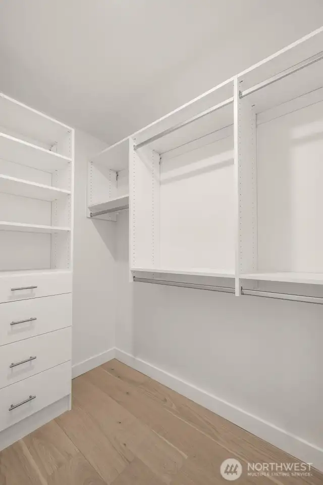 A custom walk-in closet with built-in shelving and hanging storage makes staying organized a breeze in the primary suite.