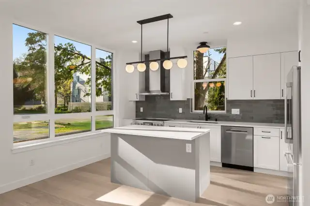 Sleek finishes and clean lines define this designer kitchen—complete with SS appliances, quartz counters, and plenty of prep space.