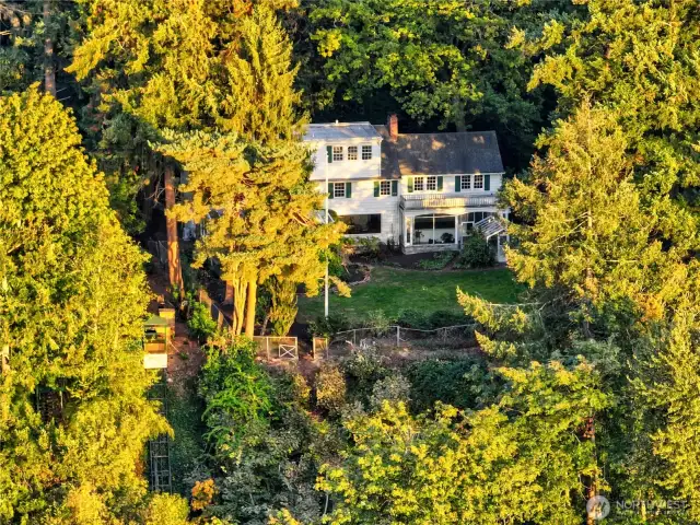 Bathed in golden hour light and nestled within a tapestry of mature evergreens, the existing residence on the property reveals itself as both sanctuary and starting point. With sweeping views over the lake and total seclusion from neighboring homes, it offers a unique opportunity to live amidst nature while being just moments from the city. Whether cherished as-is or transformed to suit a new vision, the home stands quietly within the estate’s wooded embrace—part of a rare legacy of lakeshore living.