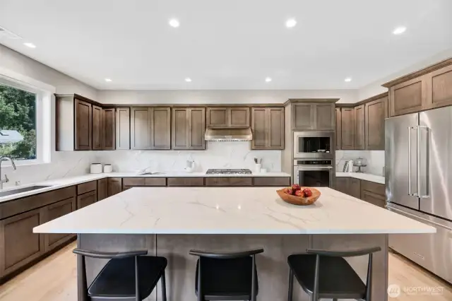 Kitchen with oversized island & stainless steel appliances.Previous built Peak house. Finishes may be different.