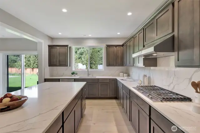 Kitchen with oversized island & stainless appliances. Previous built Peak house. Finishes may be different.