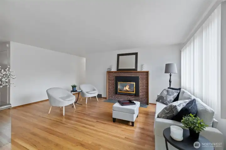 Another view of the living room and fireplace. New outlets and light switches throughout the home, new hardware on the doors and a fresh coat of paint. This home is ready for your visions.