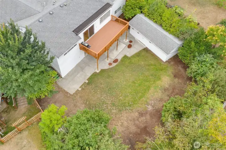 Great shot showing the rear of the home, the deck, and storage shed.