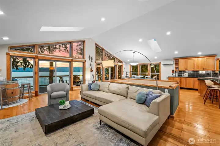 Wide-open great room for gathering. Vaulted Ceilings and walls of windows rising toward the sky