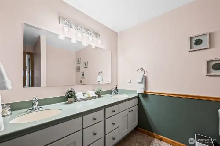 Dual sinks in primary bathroom with Corian counters.