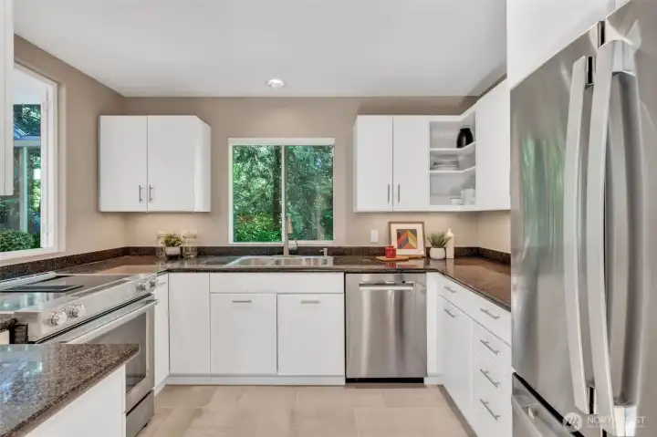 Updated kitchen features tiled floor, Stainless Steel Appliances, underlit cabinets and slab granite counters