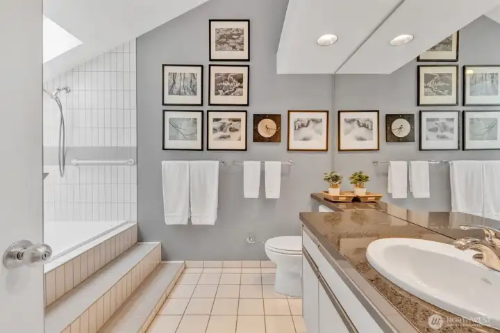 Primary bath features vaulted ceiling, tiled floor, granite counter and oversized soaking tub/dual shower