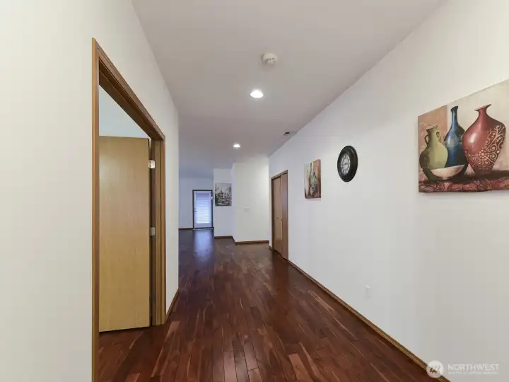 Entry of the Home. Gorgeous Teak Flooring. Wide Hallway. French Doors to Front Room/Den.