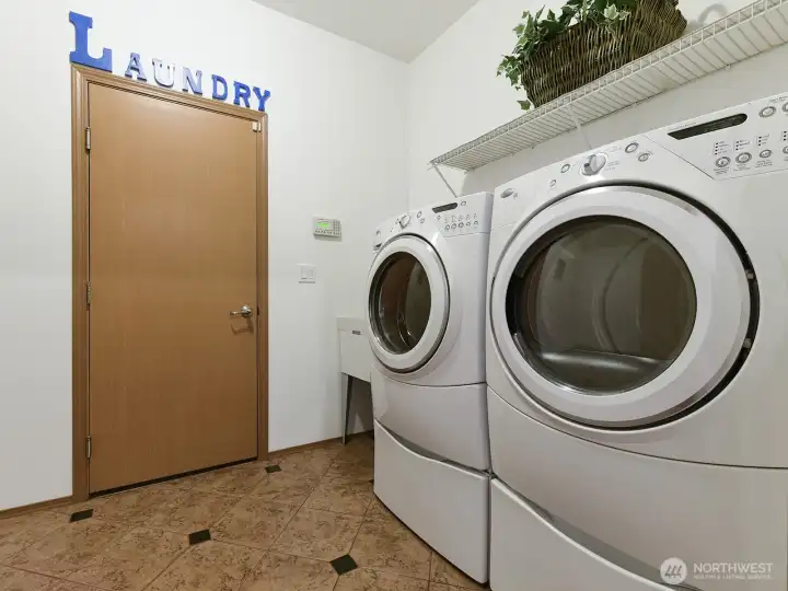 Utility Room coming from Garage. Tile flooring. Wash sink. Washer dryer stay with home sale.