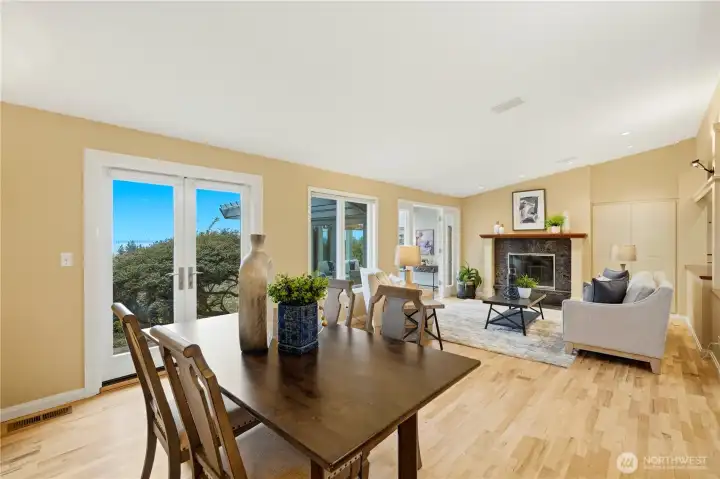 The dining area opens to the cozy living room, complete with a fireplace. Multiple french doors provide easy access to the outdoors.