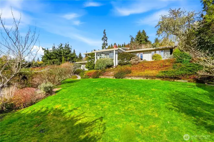 The property sits on a sprawling lot with multiple garden areas.