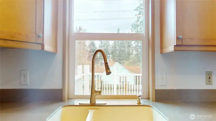 The kitchen sink overlooks the expansive back deck and yard.