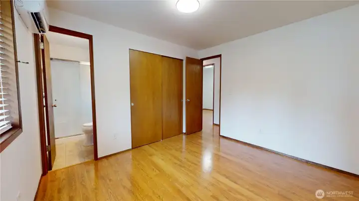 The primary bedroom, showing the door to the 3/4 bath ensuite and door to hallway.