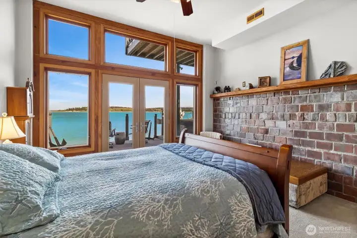 Main-level primary suite at 1442 Seacrest opens directly to waterfront views across Hales Passage toward Portage Island & Mt Baker, with the home’s extraordinary placement just 8 feet from the shoreline bulkhead creating a true “on-the-water” living experience rarely found today. Large view windows & direct deck access capture sunrise light, passing boats & year-round wildlife from one of the most uniquely positioned shoreline bedrooms on Lummi Island.