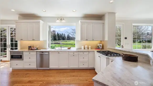 Under-cabinet lighting, pull-out drawers, and Venus Leathered Quartzite stone counters make cooking a dream