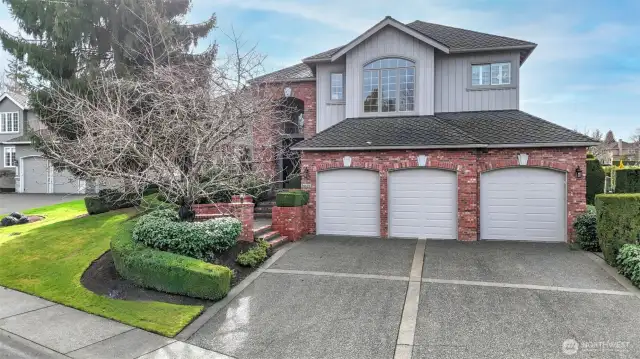 The three-car garage is highlighted by a large driveway with brushed concreted borders, providing ample room for guests to park.