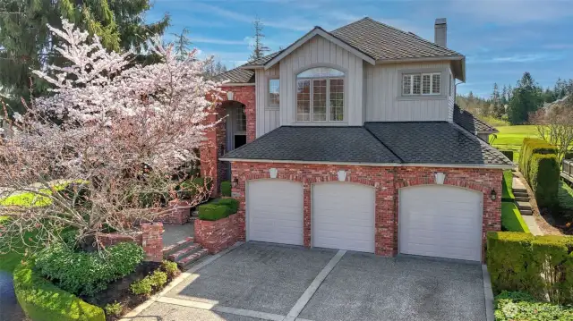 The three-car garage is highlighted by a large driveway with brushed concreted borders, providing ample room for guests to park.