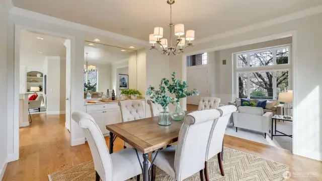 Light and airy formal dining features a large stone-topped buffet with custom cabinetry