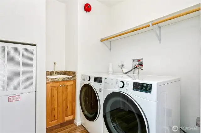 This home is equipped with a sprinkler system and a fire alarm, including the red bell on the wall. An additional alarm outside the laundry room alerts neighbors in case of fire.