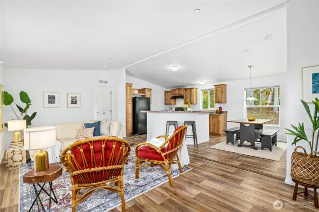 The spacious great room features a vaulted ceiling and seamlessly combines a cozy sitting area, a welcoming dining space, and a well-appointed kitchen.  All of the appliances are so lightly used, they're like brand new.